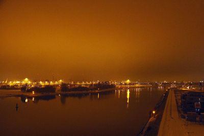 Blick auf Promenade, orangefarbener Nachthimmel in der Überseestadt Bremen
