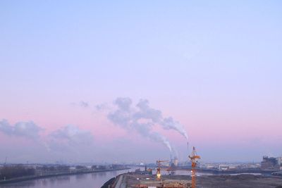 Kräne in Überseestadt Bremen und Abgasfahnen des Kohlekraftwerks