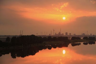 Orangefarbener Sonnenuntergang, auf der Weser spiegelnde Sonne in Bremen