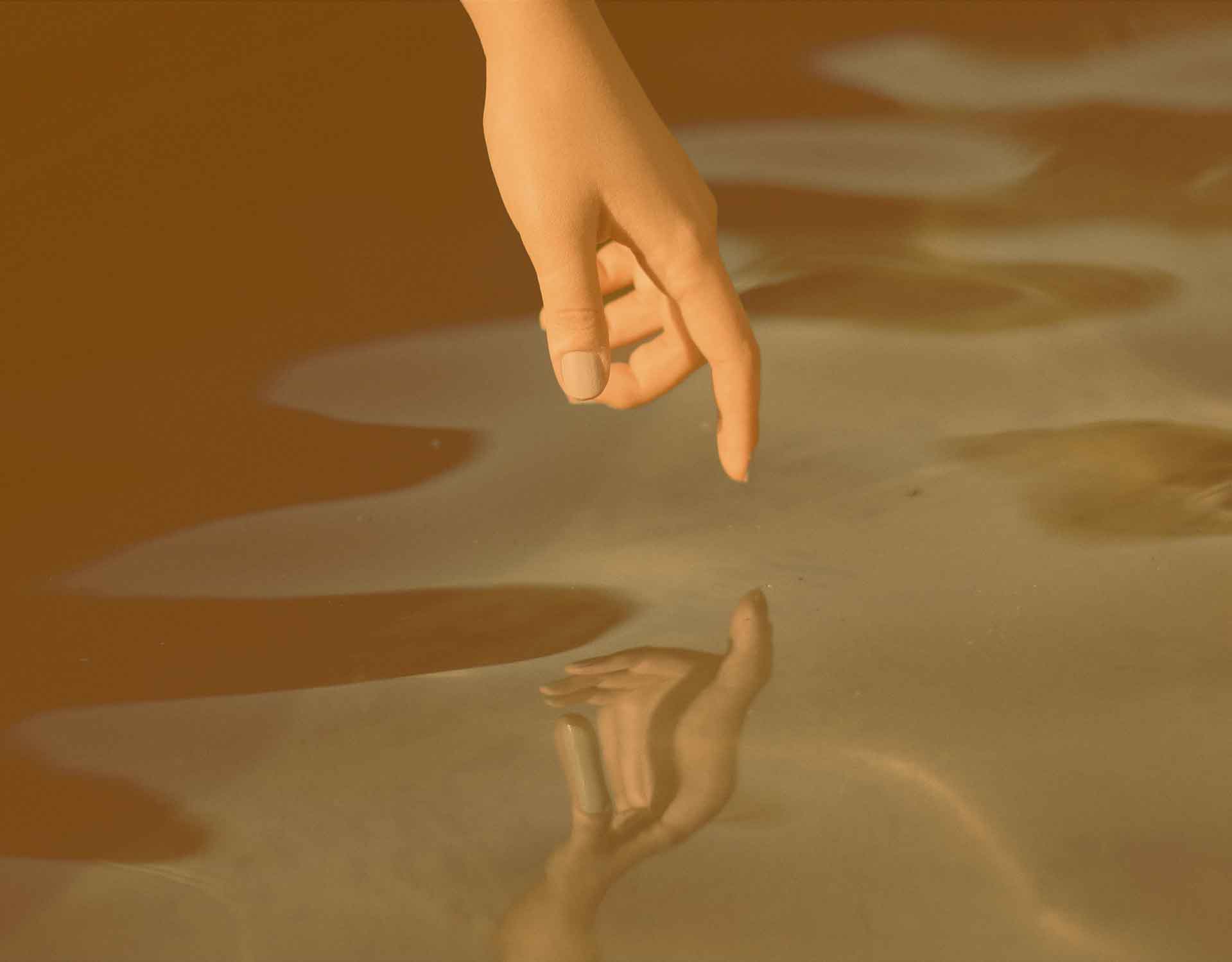 Finger spiegelt sich im Wasser