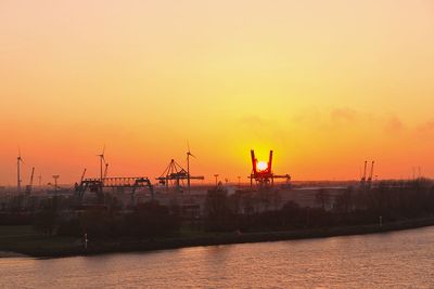 Zwei Kräne des Neustädter Hafen in Bremen halten die Sonne fest