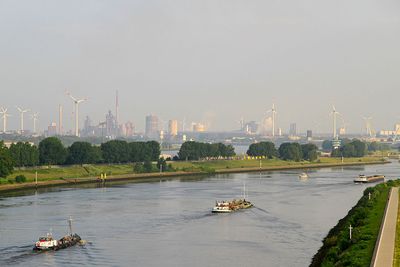 Partikulierschiffe und Motorboot auf der Weser bei Bremen, Industrieanlagen