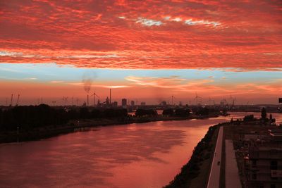 Promenade der Überseestadt Bremen, orange Wolken, blauer Himmel über Weser