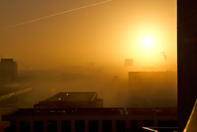 Die gelbe Sonne bricht durch den Nebel in der Überseestadt Bremen