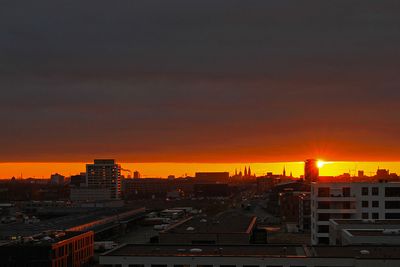 Die Wolkendecke wegschiebende Sonne über der Überseestadt Bremen