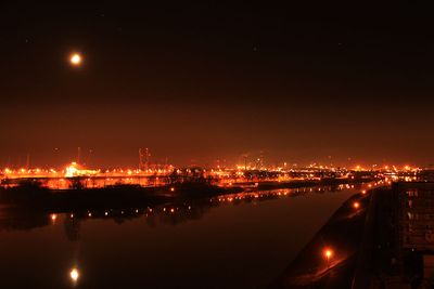 Mond und Lichtermeer der Hafen- und Industrieanlagen bei Nacht in Bremen