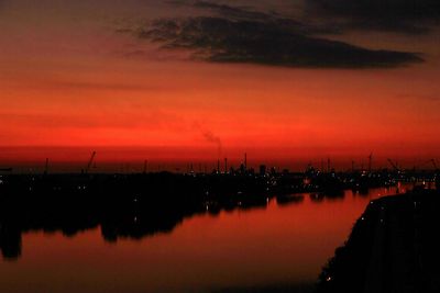 Hafen- und Industrieanlagen vor rotem Nachthimmel und Spiegelung auf Weser