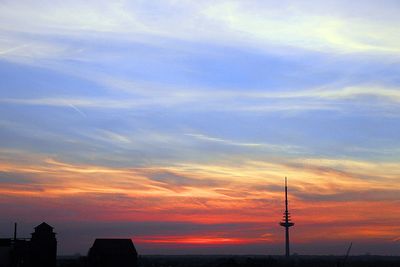 Funkturm-Silhouette, rot aufgehende Sonne, blauer Himmel über Bremen
