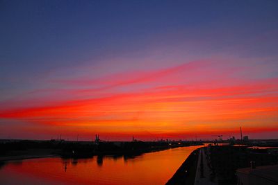 Spiegelung roter Wolken in Weser nach dem Sonnenuntergang in Überseestadt
