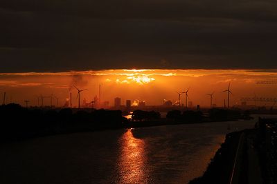 Abendstimmung an Weser, Industrie, Windräder, Sonne unter Wolkendecke