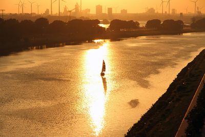 Gelbe Abendstimmung, Sonne und Segelschiff spiegeln sich auf der Weser