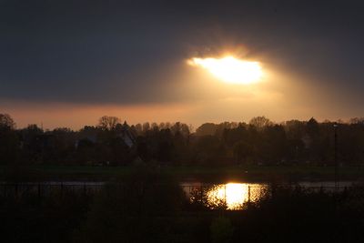 Sonne scheint durch Wolkenloch und spiegelt sich auf der Weser